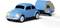 Blauwe modelauto in retrostijl met glanzende koplampen trekt kleine caravan. Het symboliseert reizen en avontuur.