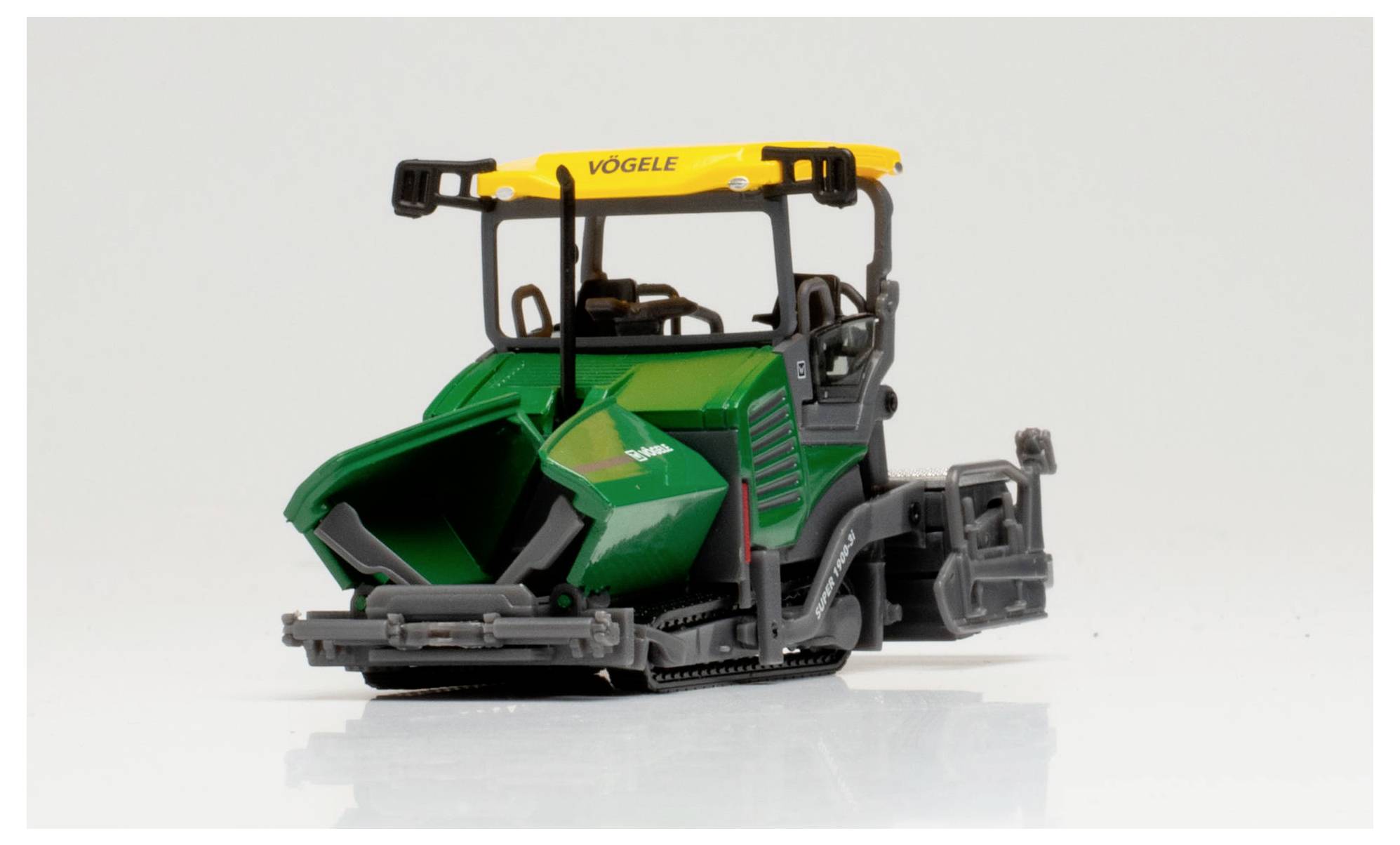 Een model van een groene en gele Vögele asfaltspreidmachine, waarbij de gedetailleerde constructie en compacte ontwerp worden tentoongesteld tegen een effen achtergrond.