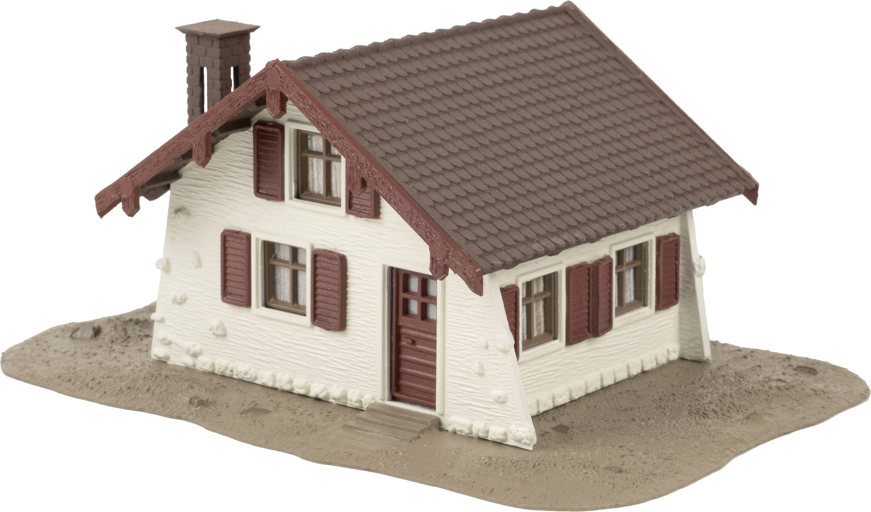 Een klein model van een huis met een schuin, donkerbruin dak en witte muren. Het heeft bruine luiken en een deur.