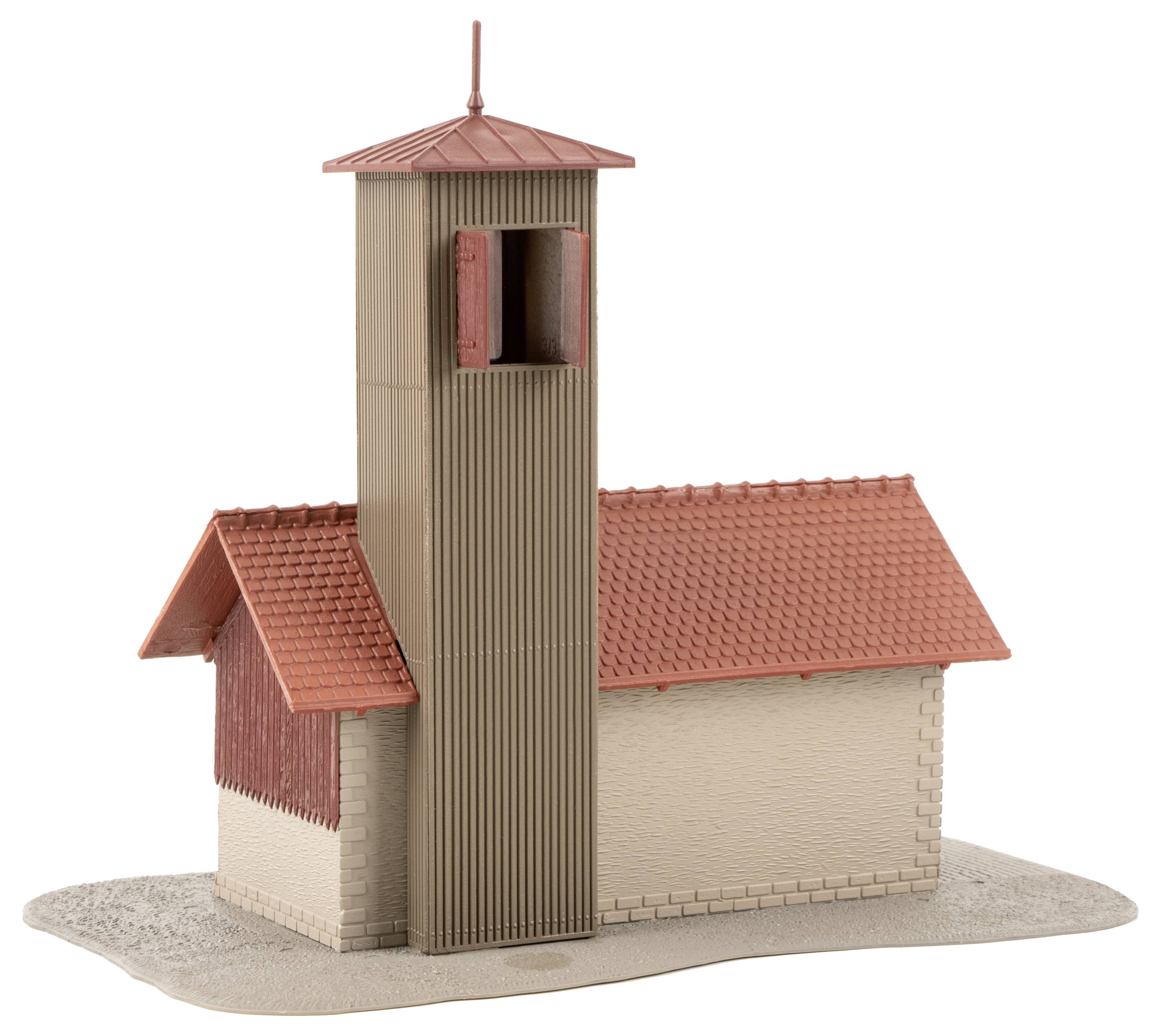 Een model van een kleine kerk met een rood pannendak en een hoge kerktoren. Het gebouw staat geplaatst op een zandkleurige basis.