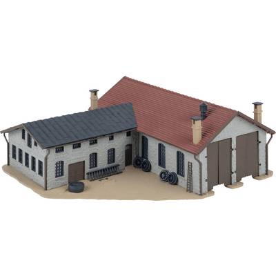 Een model van een boerderijgebouw met twee met elkaar verbonden gebouwen. Het dak van een deel is rood, het andere is grijs. Banden en ladders leunen tegen de muren.