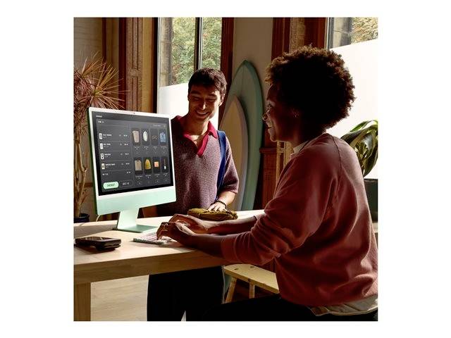 Twee personen communiceren vrolijk in een modern, licht kantoor. Eén persoon bedient een computer, terwijl de ander ernaast staat.