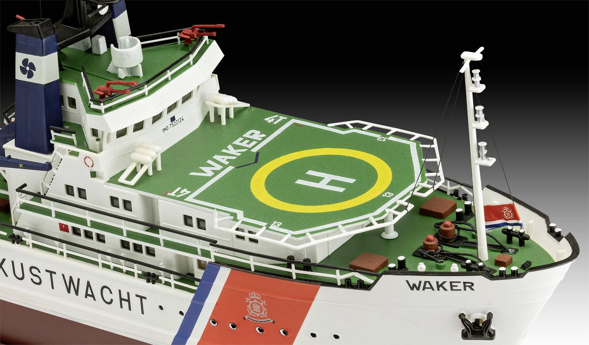 Kustwachtschip met een groene helikopterlandingsplaats, voorzien van de opschrift 'WAKER'. Reddings- en communicatieapparatuur zichtbaar.