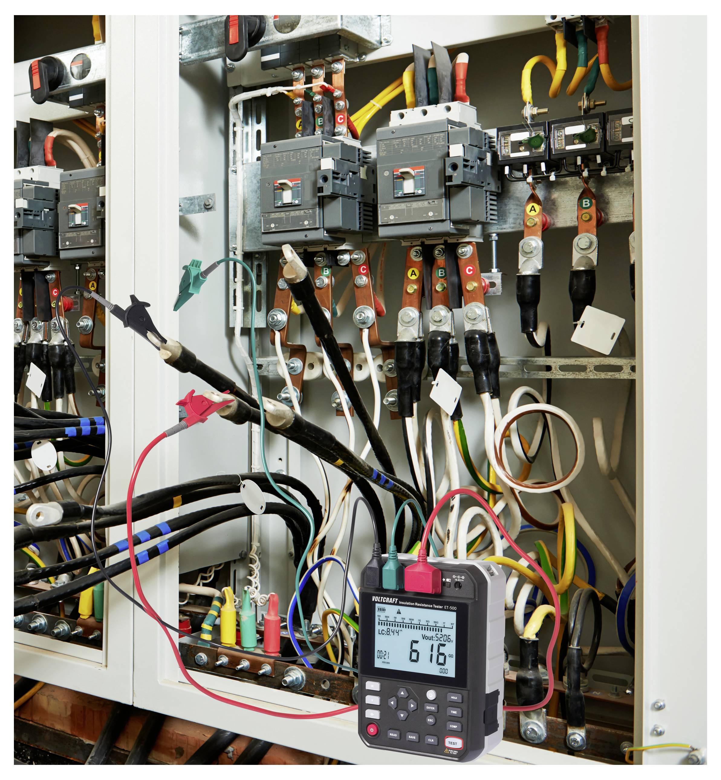 Een elektrisch paneel met meerdere gekleurde draden wordt getest met behulp van een digitale multimeter, die een waarde van '6.16' weergeeft.