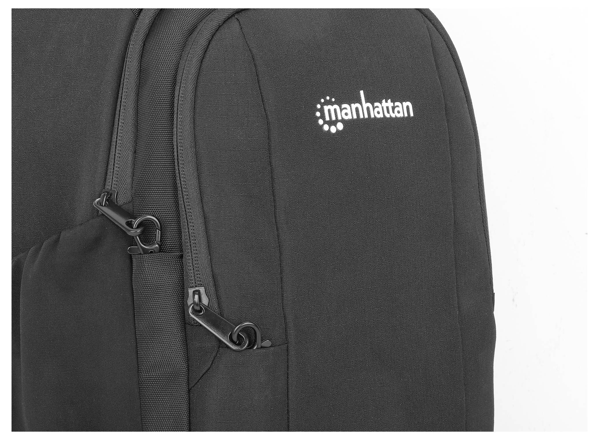 Zwarte rugzak met 'manhattan' logo op de voorkant, ritssluitingen zichtbaar.