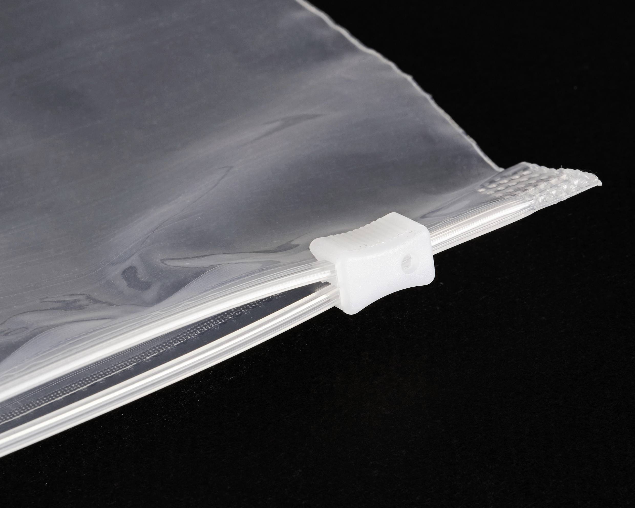 Een transparante plastic zak met een witte schuifritssluiting op een zwarte achtergrond. De zak is gedeeltelijk geopend.