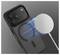 Een zwarte smartphone met een gemarkeerde ring aan de achterkant, gepositioneerd naast een ronde draadloze oplader die blauw licht uitstraalt.