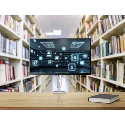 Een monitor op een bibliotheekbalie toont digitale pictogrammen, wat wijst op een thema van technologie-integratie in het leren. Naast de monitor ligt een boek.
