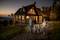 Een familie wandelt bij zonsondergang over een pad naar een houten huis. De omgeving is groen en bebost.