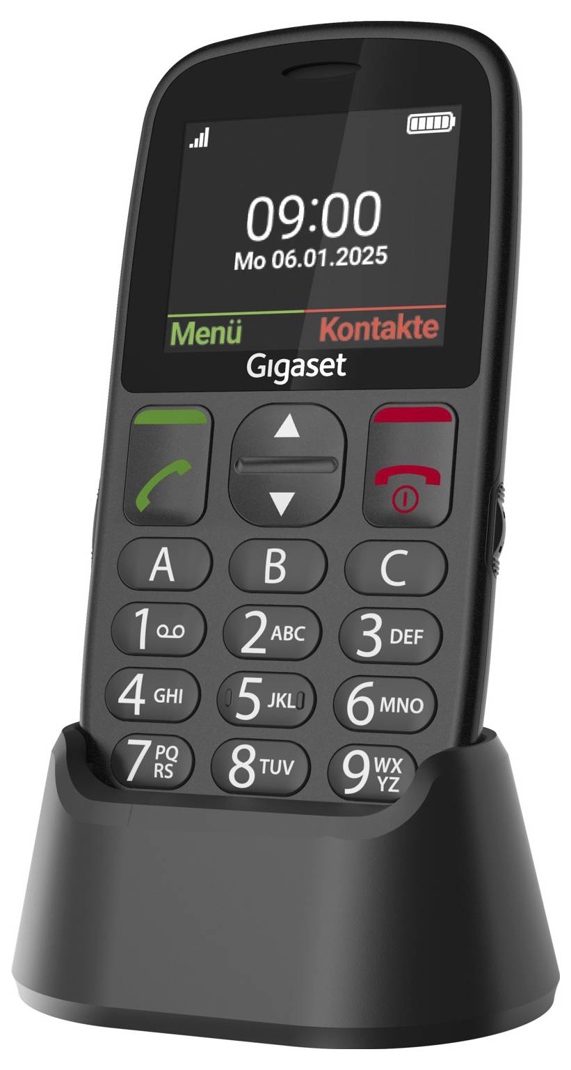 Zwarte seniorentelefoon met grote toetsen en oplaadstation. Op het scherm staat '09:00 Ma 06.01.2025'. Optietoetsen voor 'Menu' en 'Contacten'.