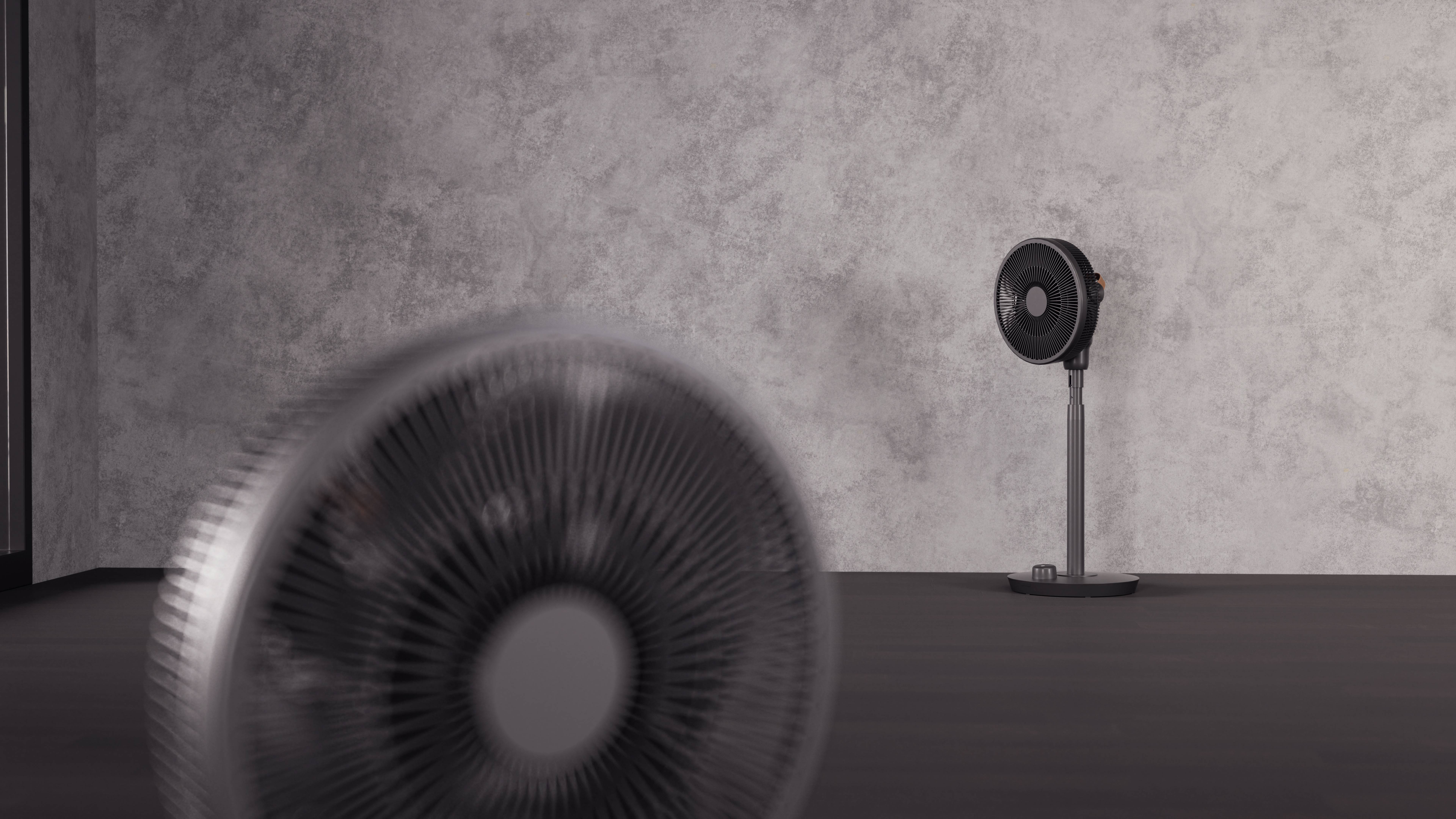 Een ventilator staat wazig op de voorgrond, terwijl een andere ventilator in de hoek van een kamer scherp te zien is.