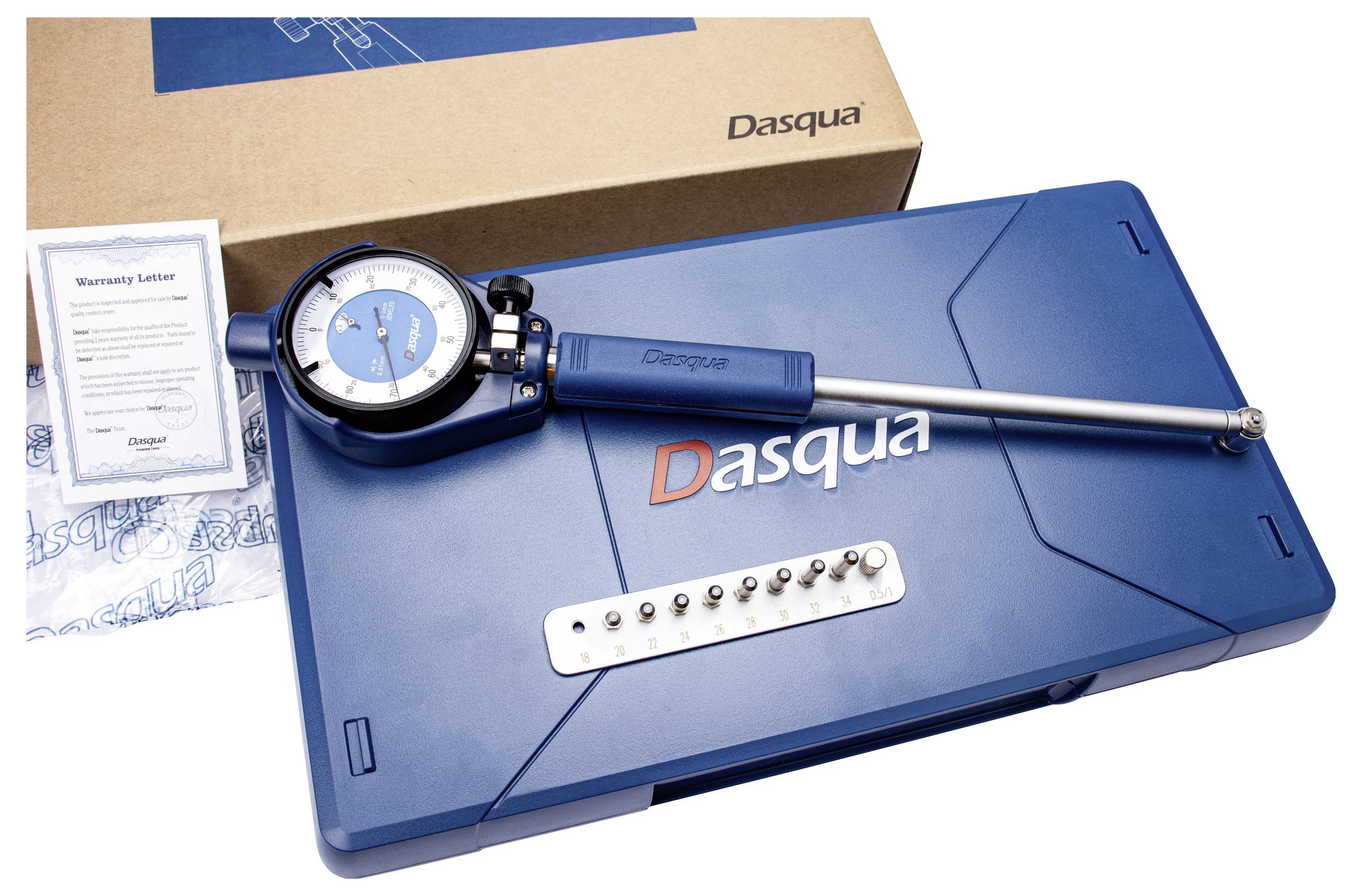 Een meetinstrumentenset in een blauwe koffer met een gemerkt deksel, een garantiebrief en een kartonnen doos. De set bevat meetklokjes en meetgereedschappen.