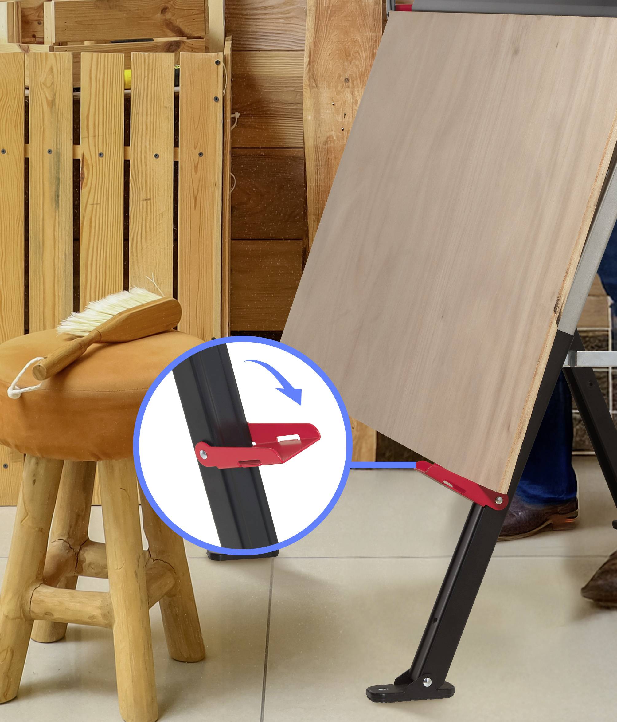 'Verstelbare schildersezel met een rood vergrendelingsmechanisme, gepositioneerd naast een houten kruk met een penseel bovenop. Houten paneel op de achtergrond.'