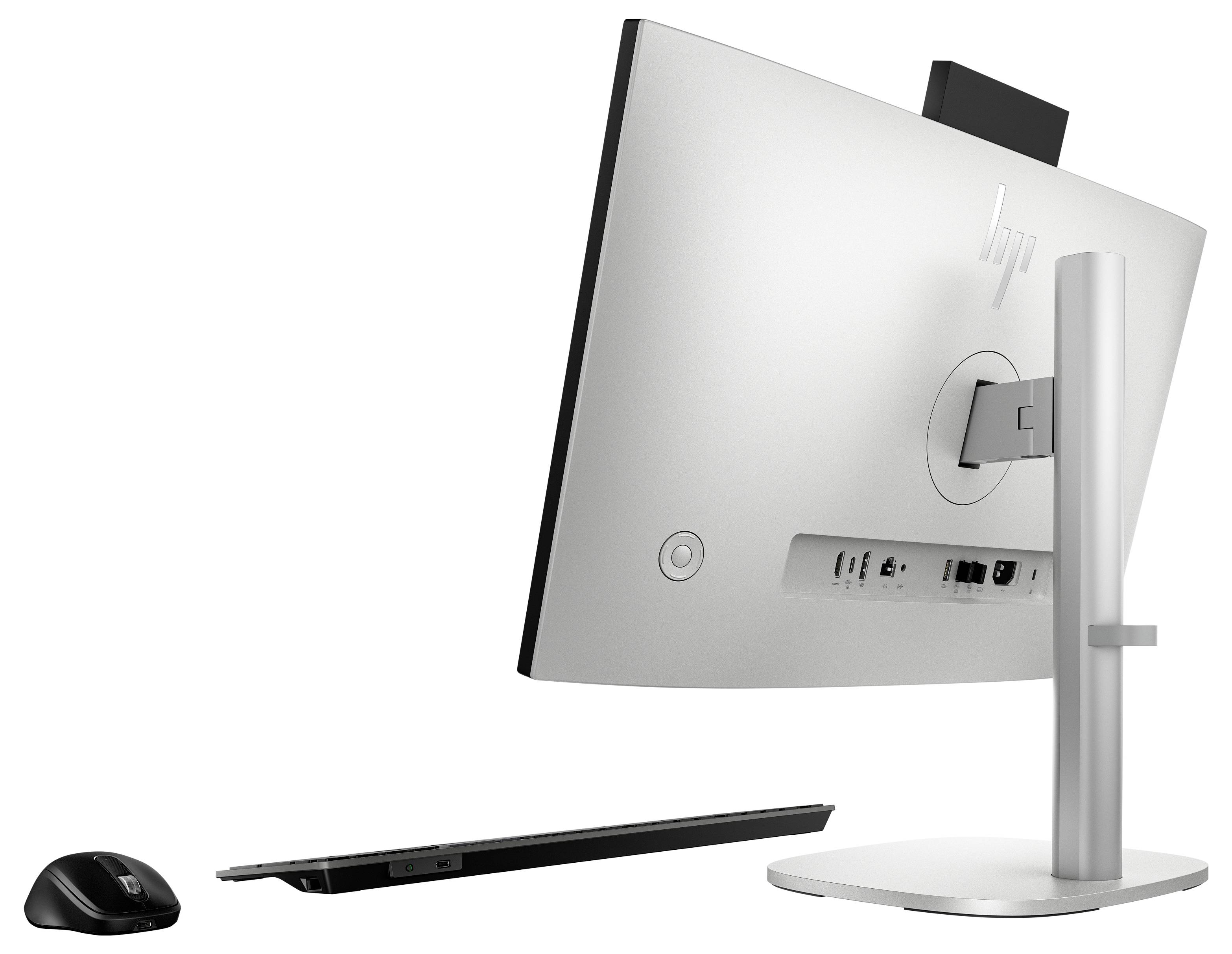 Een moderne desktop computeropstelling gezien van achteren, met zichtbare aansluitpoorten; inclusief draadloze muis en toetsenbord.