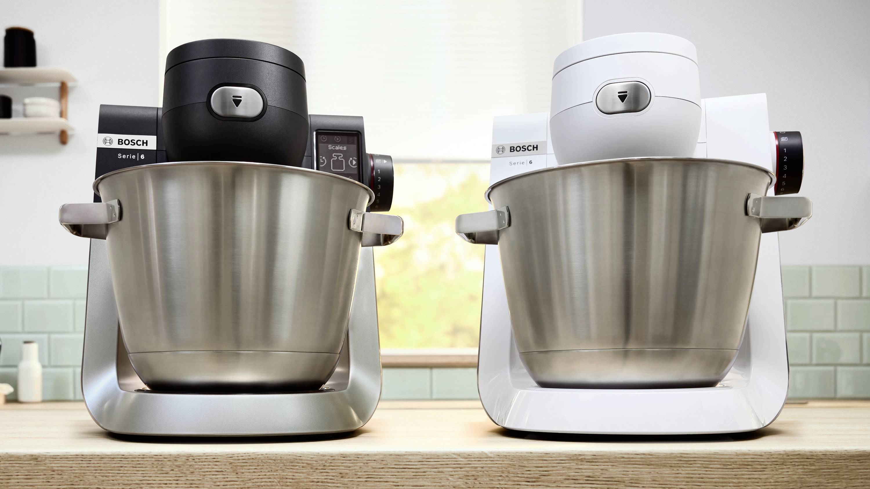 Twee standmixers, één zwart en één wit, met roestvrijstalen kommen op een aanrecht, waarbij het ontwerp en de kleuropties worden benadrukt.