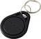 Een zwarte ronde sleutelhanger met een zilveren sleutelring, gegraveerd met cijfers. Gebruikt voor toegangscontrole of identificatie.