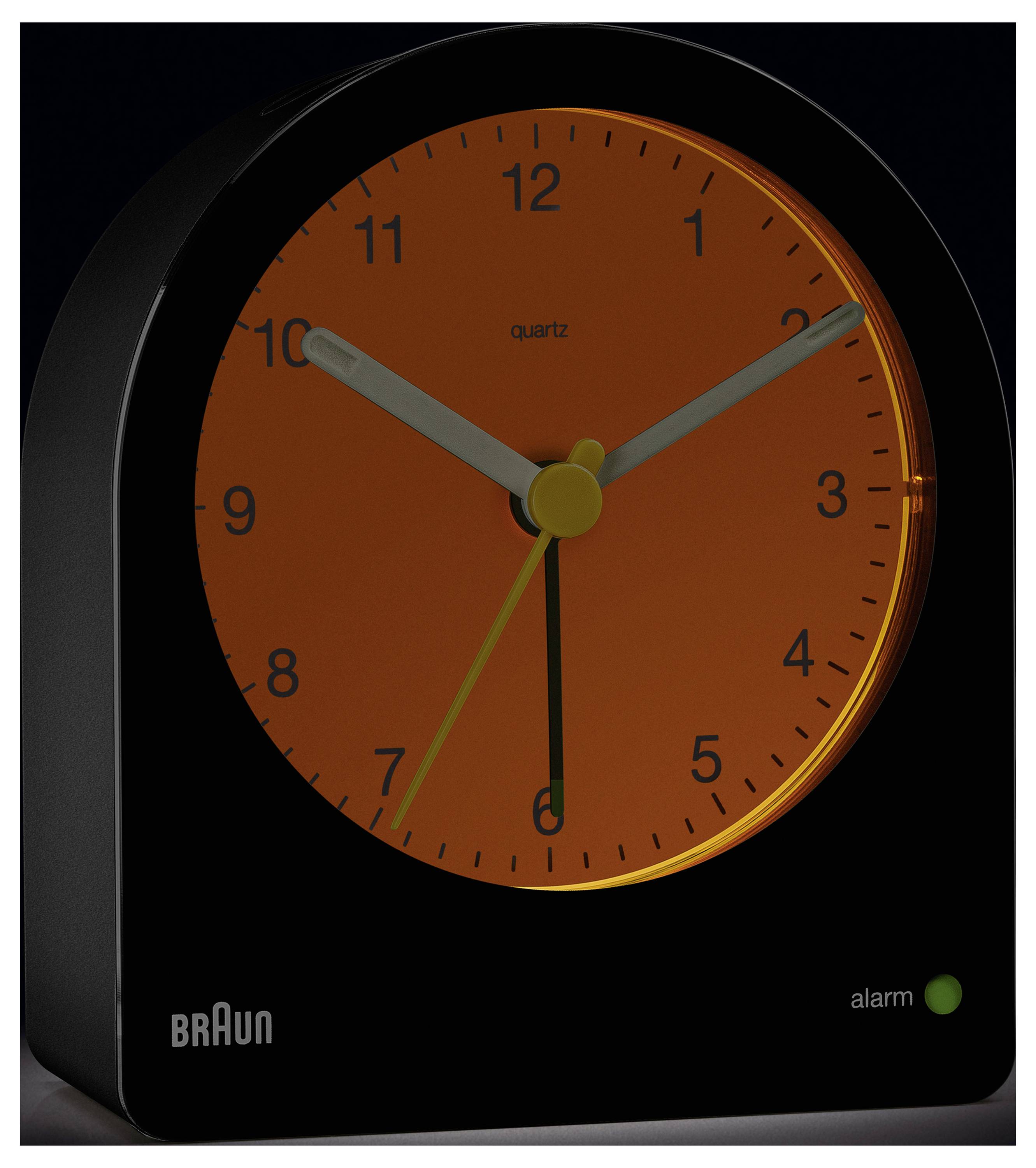 Een zwarte Braun kwarts wekker met een oranje wijzerplaat en zwarte cijfers toont de tijd als 10:10. Een groen lampje geeft aan dat de wekker is ingeschakeld.