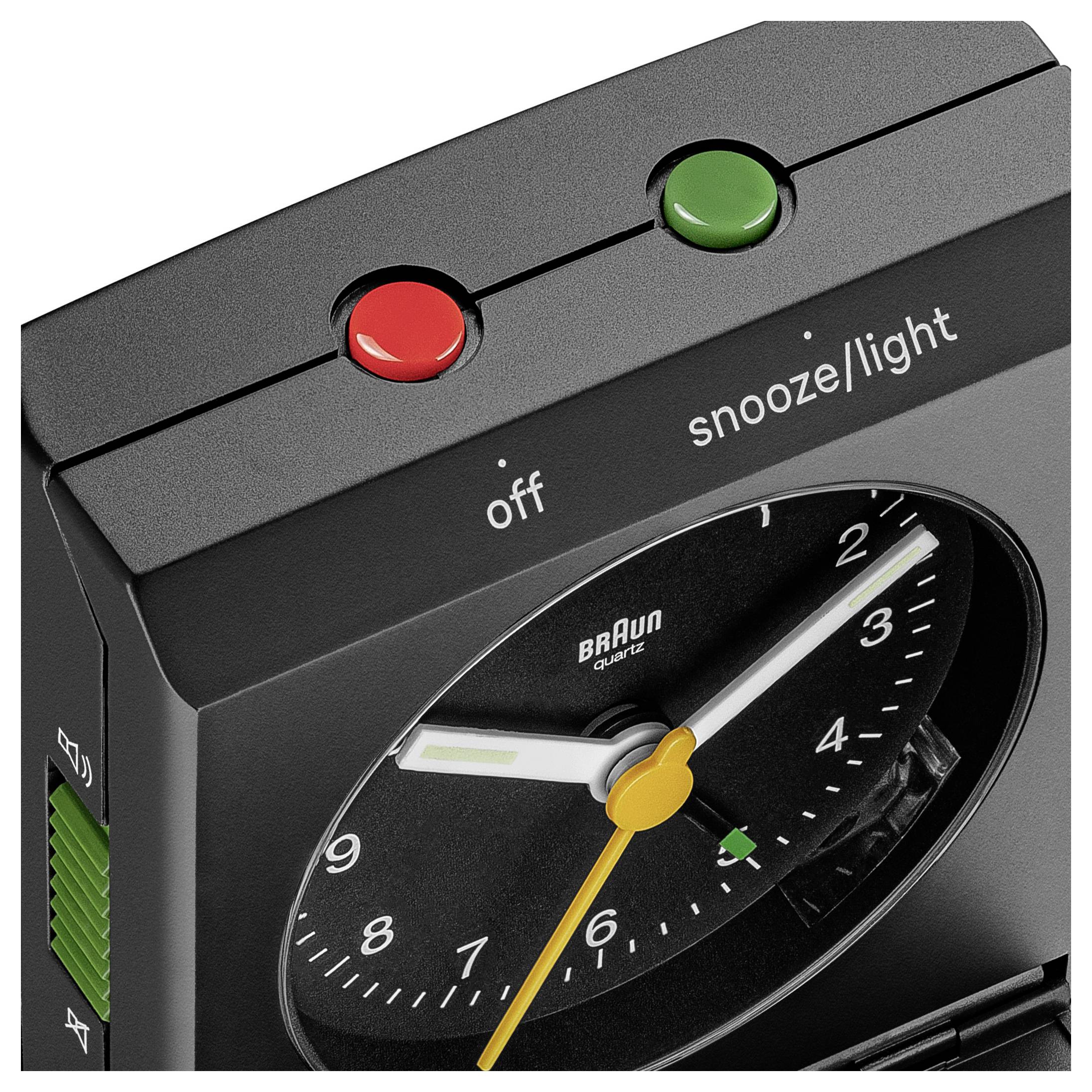 Een zwarte analoge wekker met een rode 'uit'-knop en een groene 'snooze/licht'-knop bovenop. Op de wijzerplaat wordt 10:10 weergegeven.