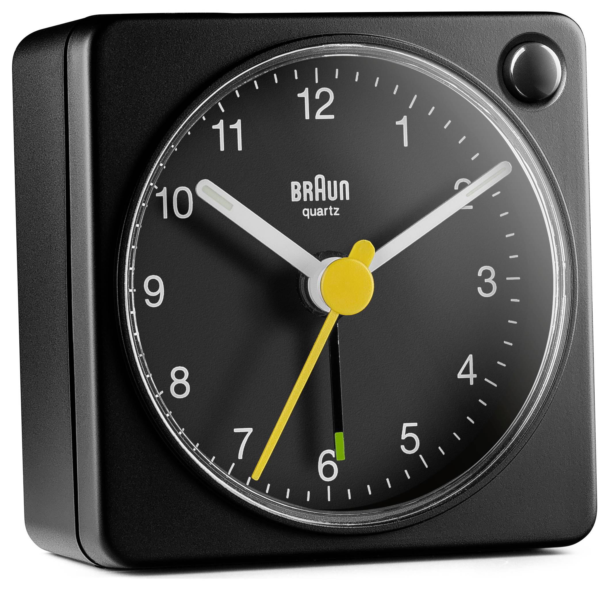 Een zwarte analoge klok met vierkante vorm, voorzien van witte cijfers en wijzers, met een gele secondewijzer en de tekst 'Braun quartz' op de wijzerplaat.