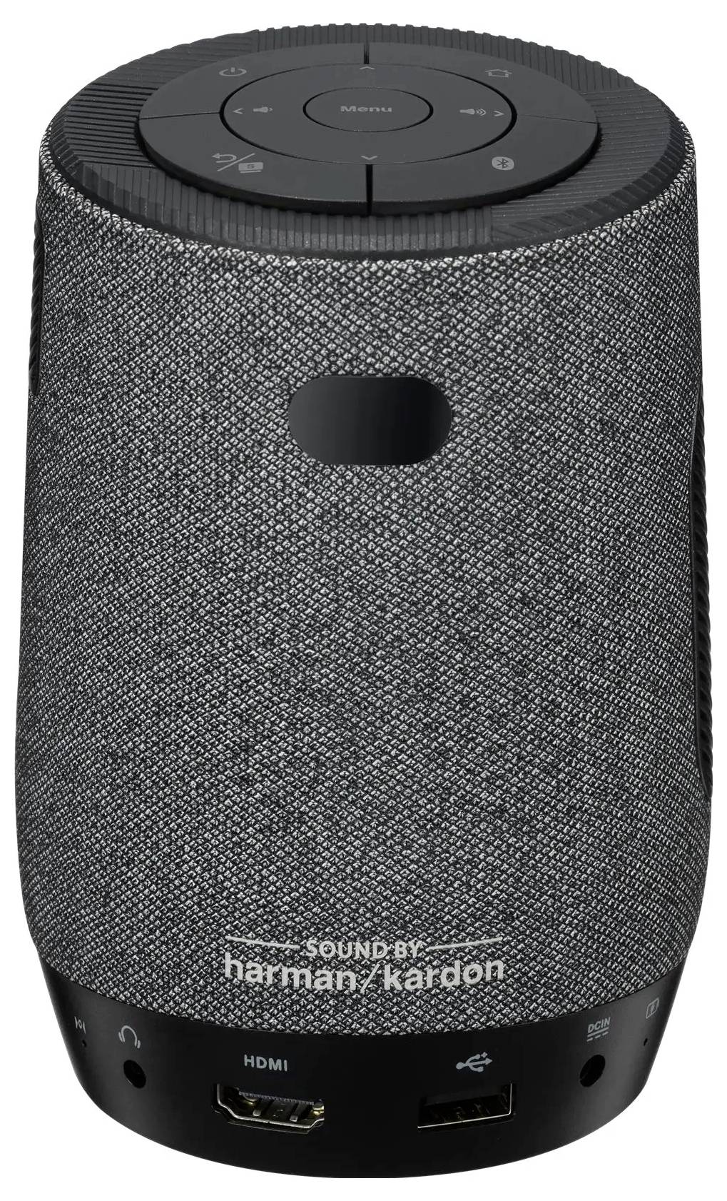 Een grijze cilindrische slimme speaker met stoffen hoes, voorzien van bedieningsknoppen bovenop en poorten aan de onderkant, gemarkeerd met 'Sound by harman/kardon'.