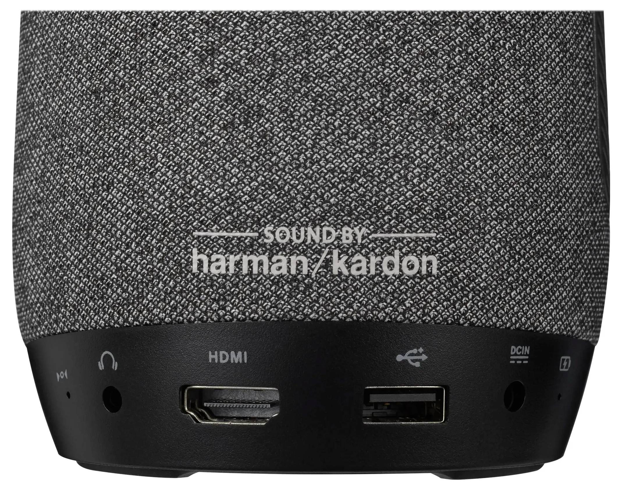 Close-up van het onderste paneel van een speaker met een gestructureerde stof en aansluitpoorten: hoofdtelefoonaansluiting, HDMI, USB en voedingsingang.