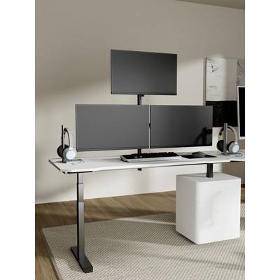 Een moderne werkplek met drie monitoren, een toetsenbord en koptelefoon op een strak, in hoogte verstelbaar bureau in een minimalistisch kantoorruimte.