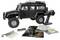 Een zwarte RC terreinwagen met accessoires waaronder een afstandsbediening, veren, stickers en gereedschappen netjes ernaast gerangschikt.