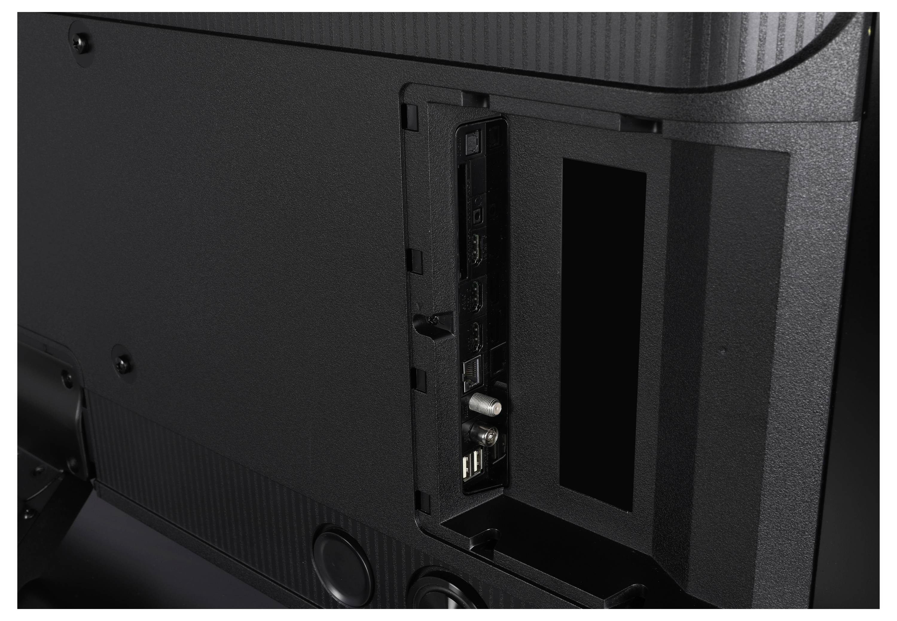 Achteraanzicht van een tv met een open paneel met meerdere poorten, waaronder HDMI, USB en andere aansluitingsmogelijkheden.