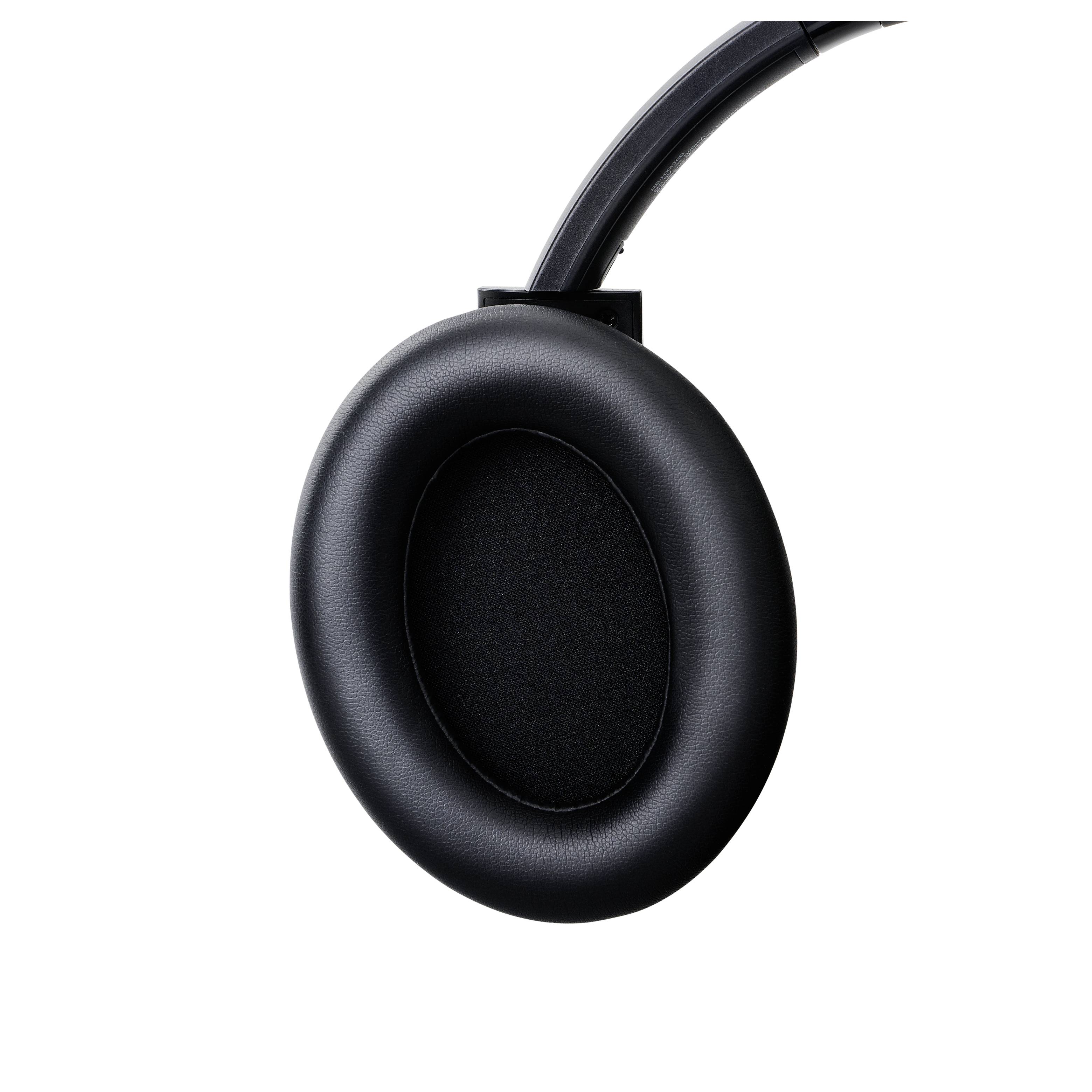 Een zwart oorkussen voor koptelefoon met een ronde vorm en gladde oppervlakte, bevestigd aan een verstelbare hoofdband.