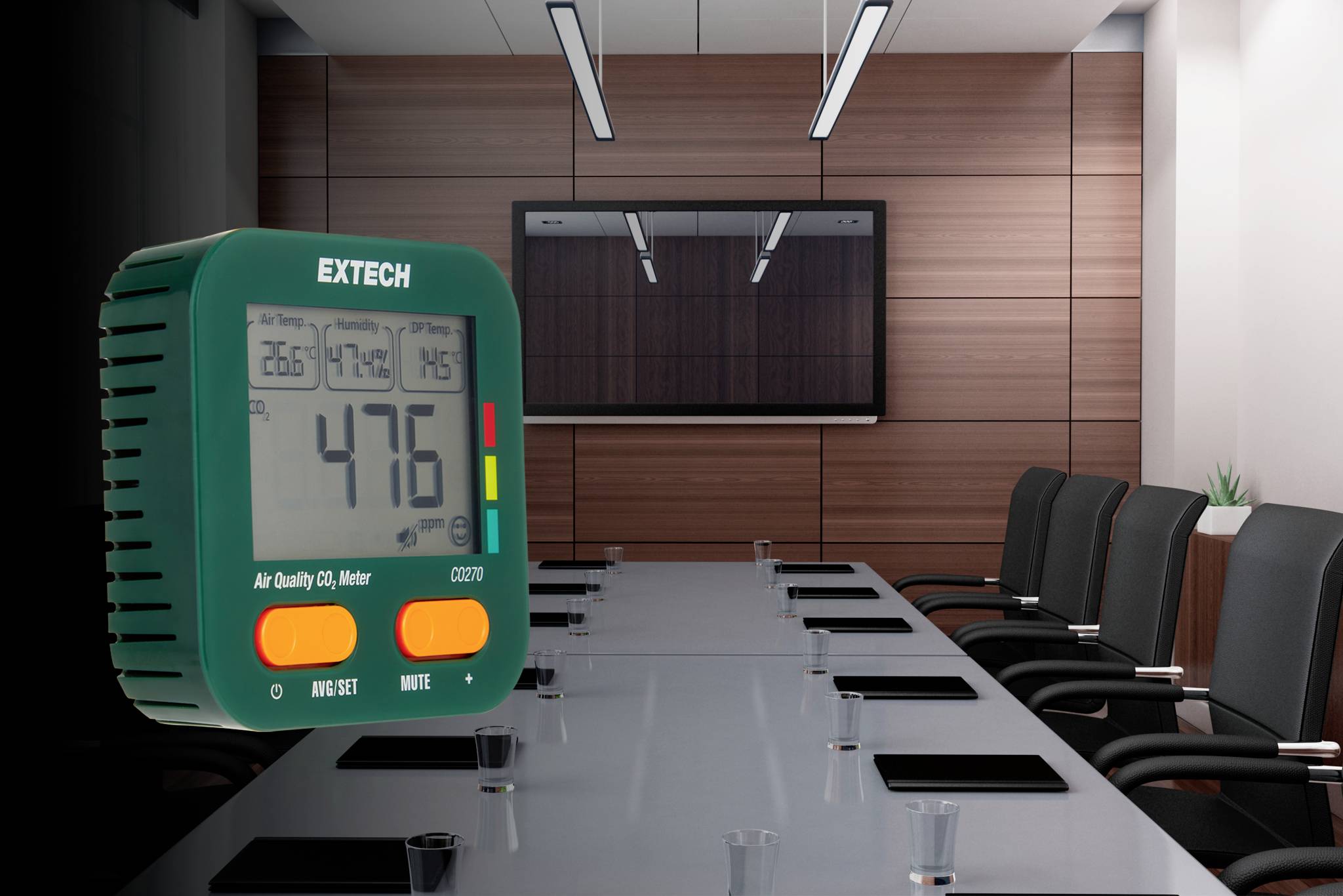 EXTECH luchtkwaliteitsmeter met '476' weergegeven, geplaatst op een boardroomtafel met een scherm en stoelen op de achtergrond.