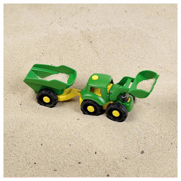 Een groene en gele speelgoedtractor met een schep op zanderige grond, met op de achtergrond glad, beige zand.