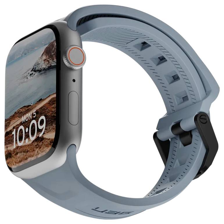 Een smartwatch met een zilveren behuizing en een lichtblauwe band toont de tijd '10:09' en de datum 'Ma 5' met een berglandschap op het scherm.
