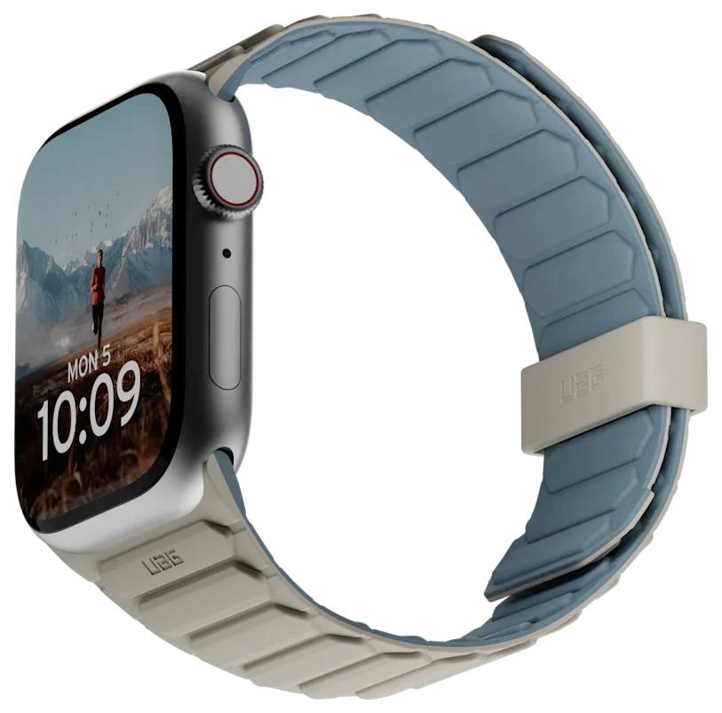 Een smartwatch met een kleurrijke landschapswallpaper op het scherm. Het display toont de datum 'Ma 5' en de tijd '10:09'. De horlogeband is beige en blauw.