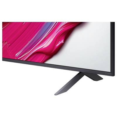Een close-up van een moderne computermonitor met een smalle rand, waarop een levendig roze en wit abstract ontwerp wordt weergegeven, geplaatst op een metalen standaard.