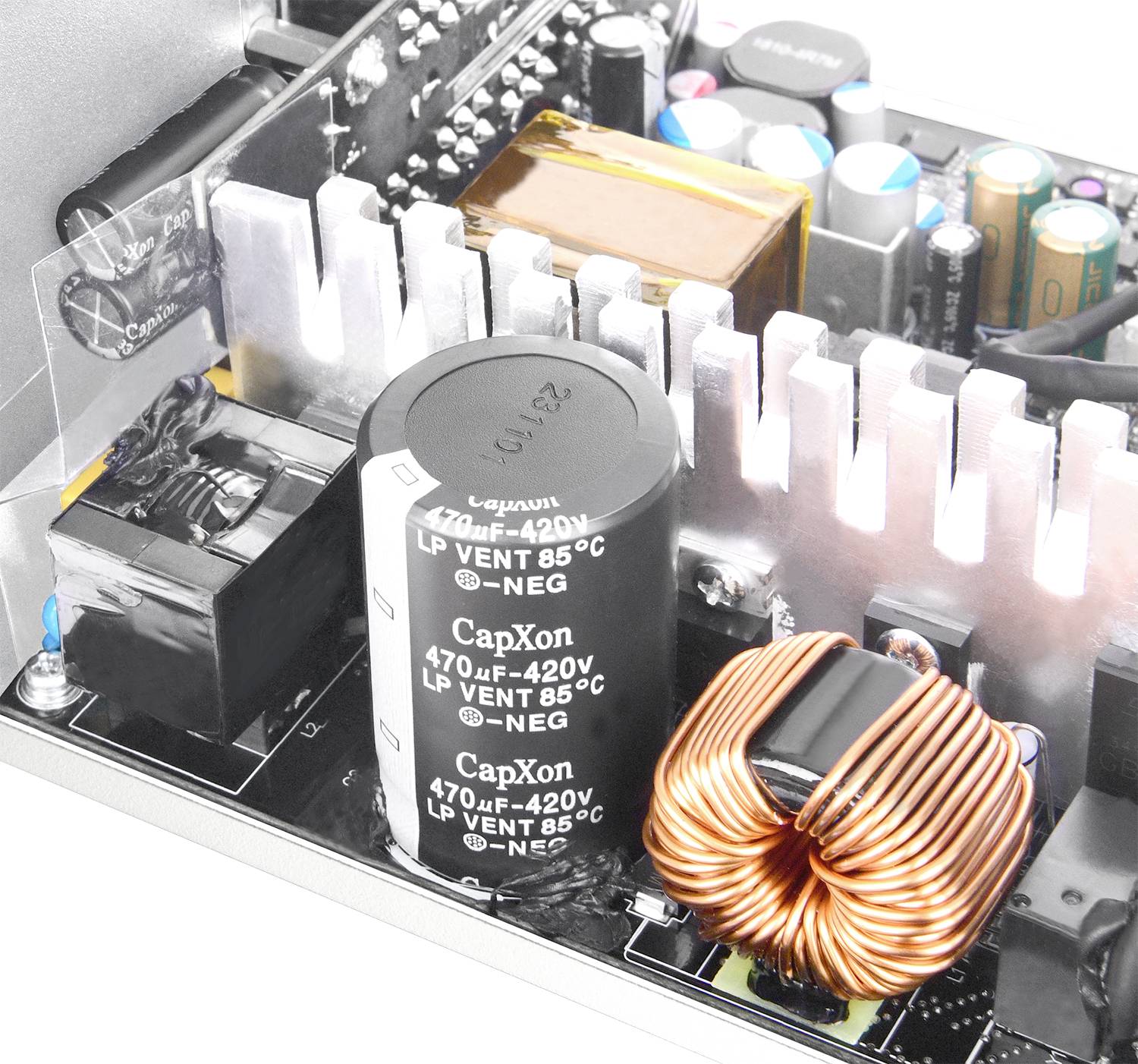 Close-up van elektronische componenten op een printplaat, inclusief condensatoren en spoelen, die de complexe elektrische techniek demonstreren.