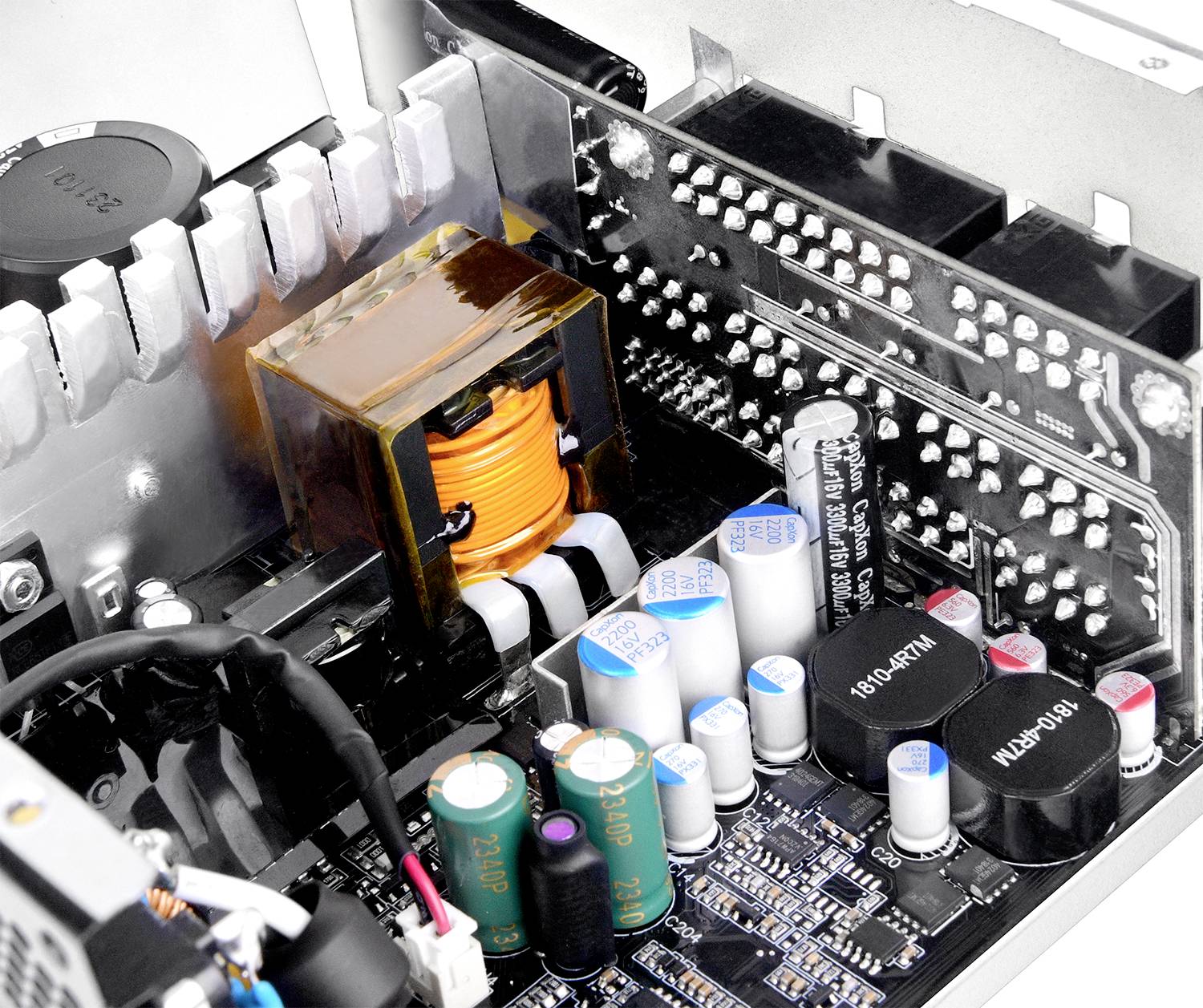 Een close-up van een computermoederbord met condensatoren, weerstanden en een spoel. De afbeelding belicht gedetailleerde elektronische componenten.