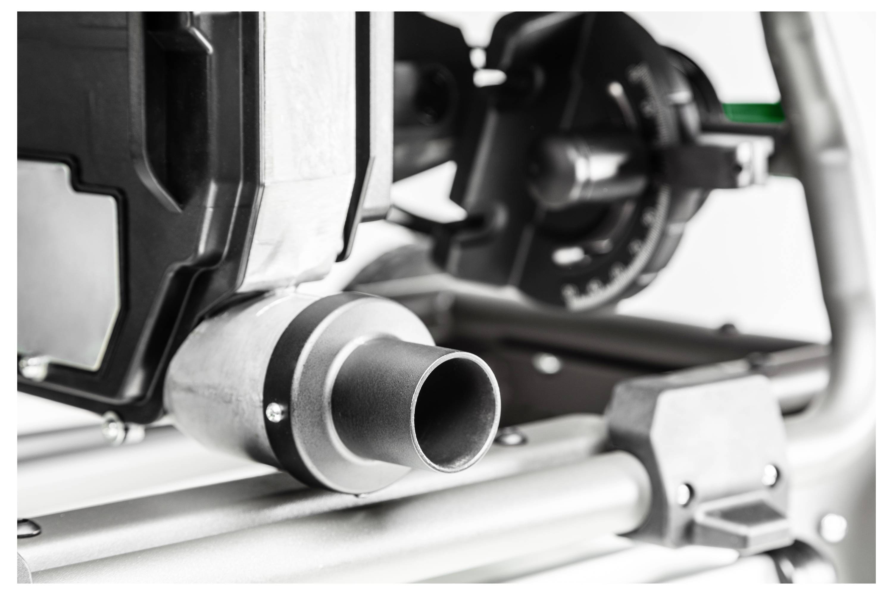 Een close-up van industriële apparatuur, gefocust op een pijp die is aangesloten op een groot machineonderdeel, waarbij bouten en metalen constructie zichtbaar zijn.