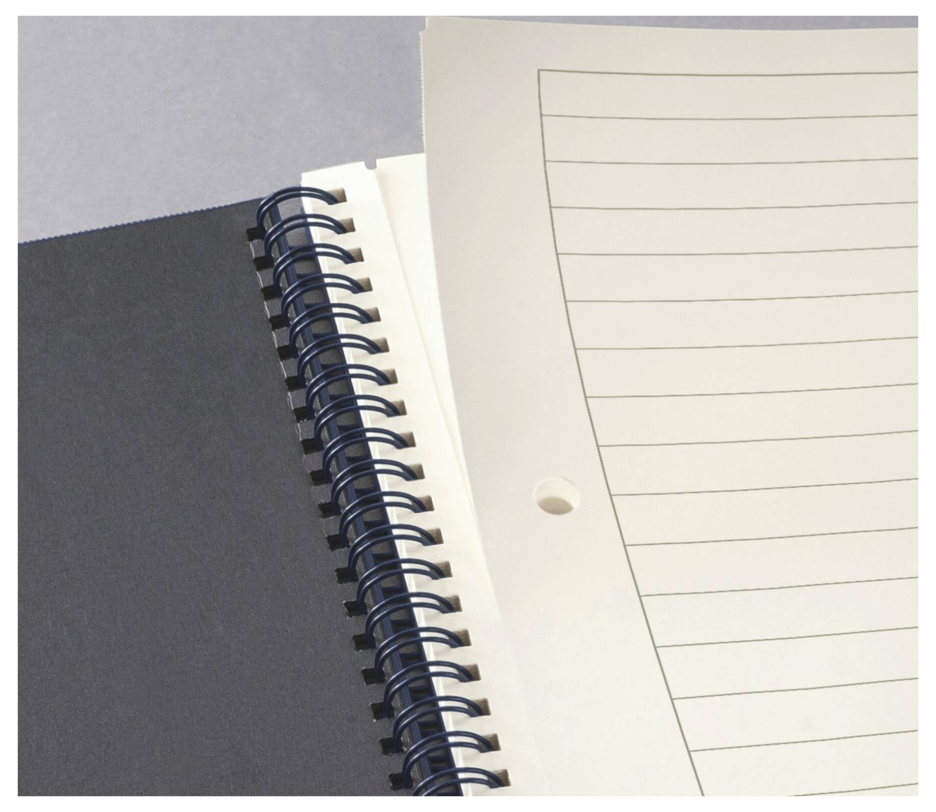 Een open spiraalnotitieblok met gelinieerde pagina's op een grijze achtergrond. De pagina's zijn leeg, klaar om te schrijven of aantekeningen te maken.