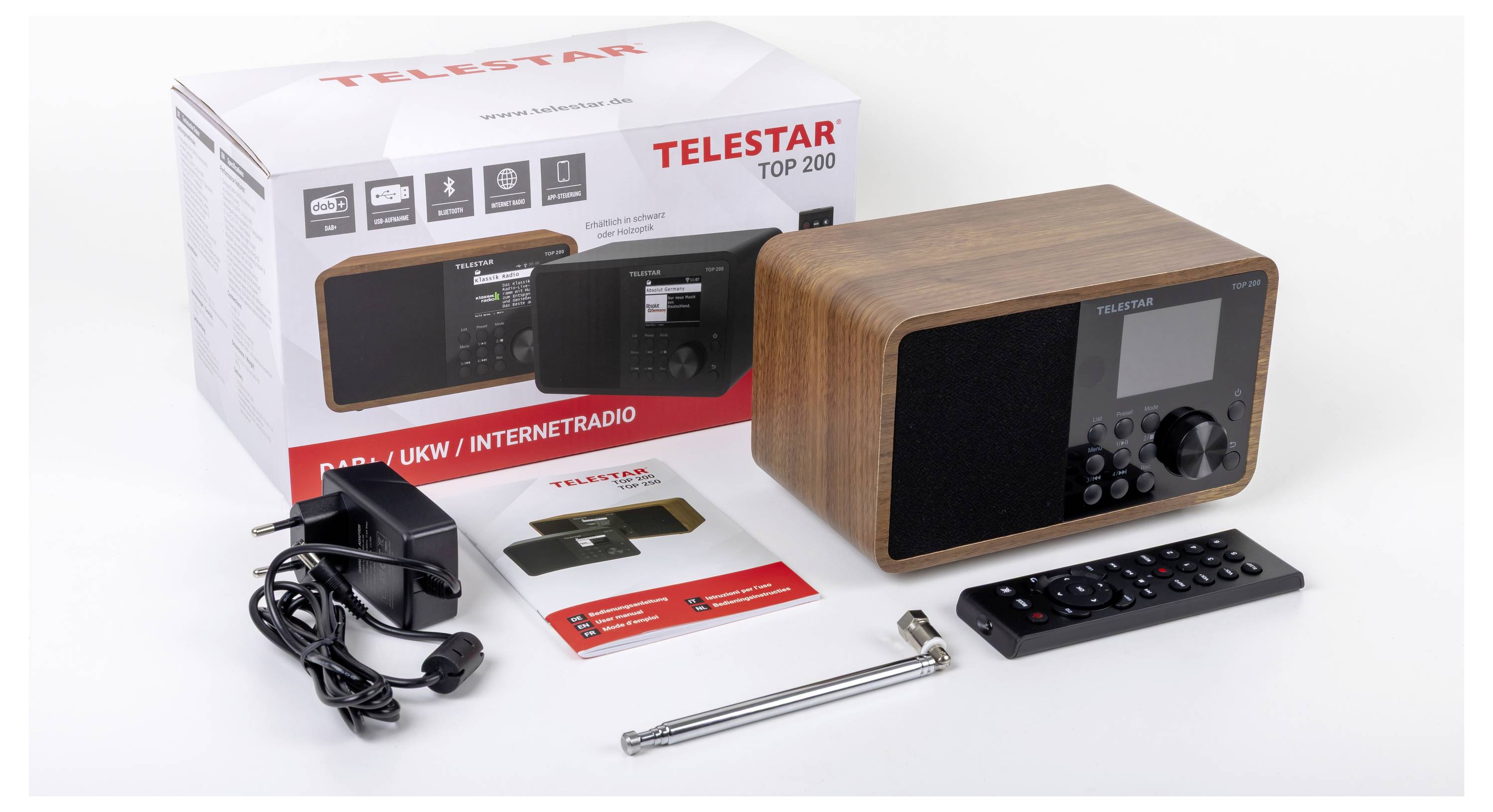 Radioset met houten afwerking, afstandsbediening, stroomadapter, antenne en handleidingen voor een productverpakking met het label 'Telestar Top 200'.