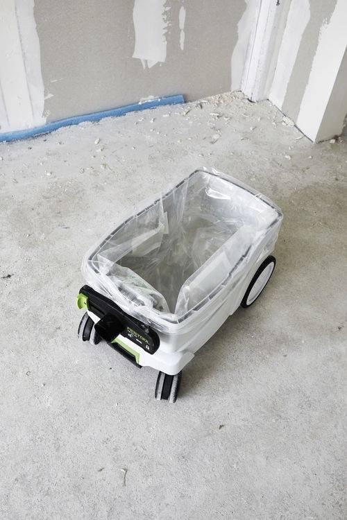 Een draagbare witte schildersemmer met wielen en een handvat staat op een betonnen vloer in een kamer die in aanbouw is.