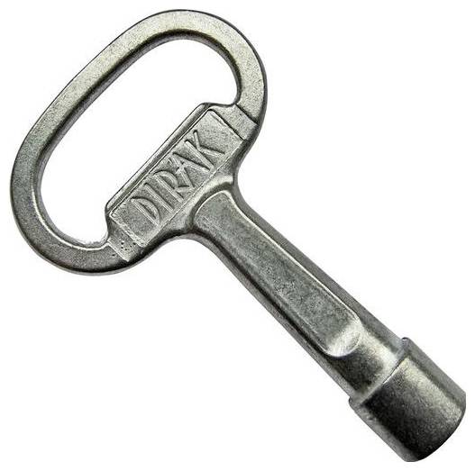 Zilveren metalen sleutel met een ovale handgreep waarop het woord 'DIRAK' is gegraveerd. De sleutel heeft een unieke vat-vormige punt.