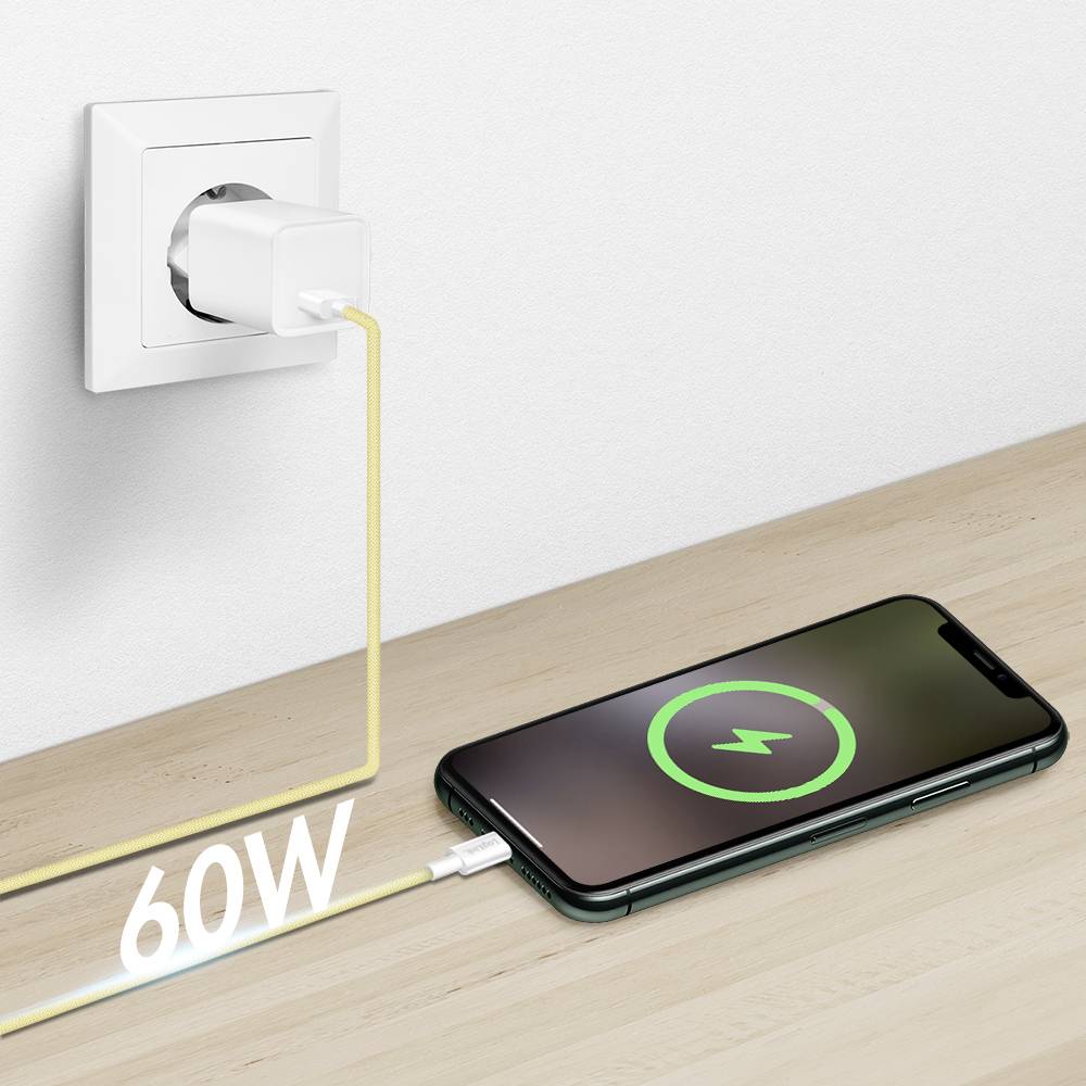 Een smartphone die op tafel aan het opladen is, aangesloten op een stopcontact. Een label toont '60W', wat de kracht van het laadapparaat aangeeft.