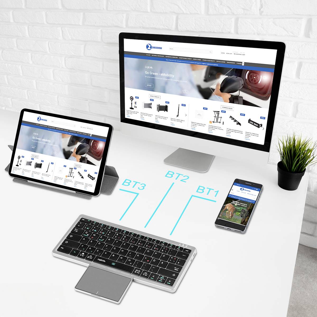 Een computerscherm, tablet en smartphone die dezelfde website weergeven, naast een draadloos toetsenbord. De setup suggereert multitasking of apparaatconnectiviteit in een kantooromgeving.