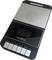 Een zwarte en zilveren draagbare cassetterecorder met knoppen voor 'opnemen', 'afspelen', 'terugspoelen', 'vooruitspoelen', 'stop/uitwerpen' en 'pauze'.