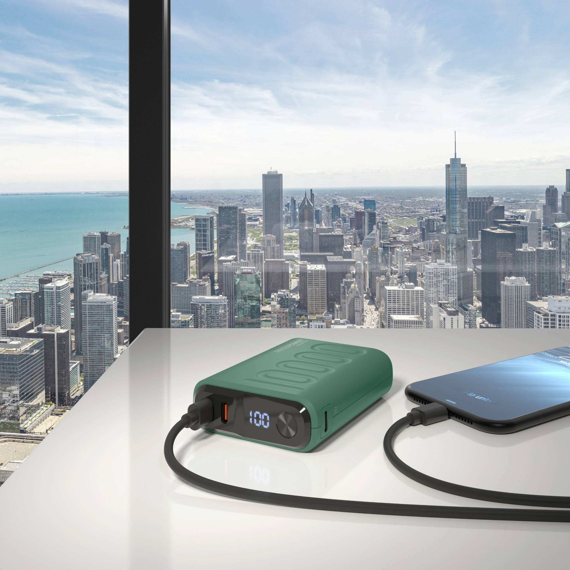 'Powerbank die een smartphone oplaadt op een tafel met een stadssilhouet op de achtergrond door grote ramen.'