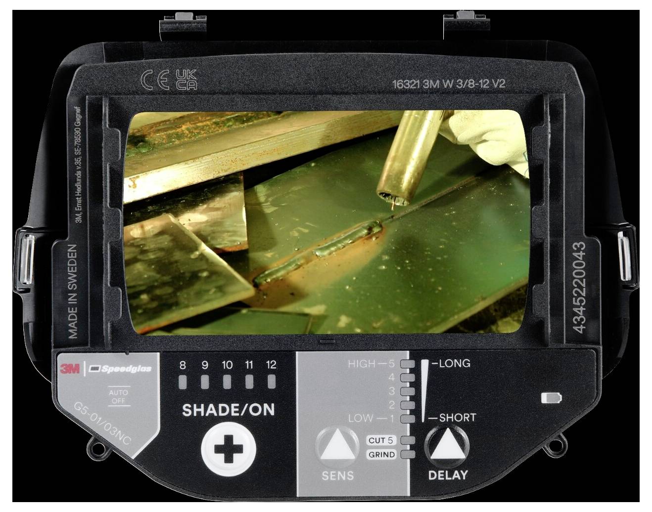 Een lasmasker vertoont door de kijker een close-up van een gehandschoende hand die metaal last, met vonken die rondvliegen, wat een werkproces aangeeft.