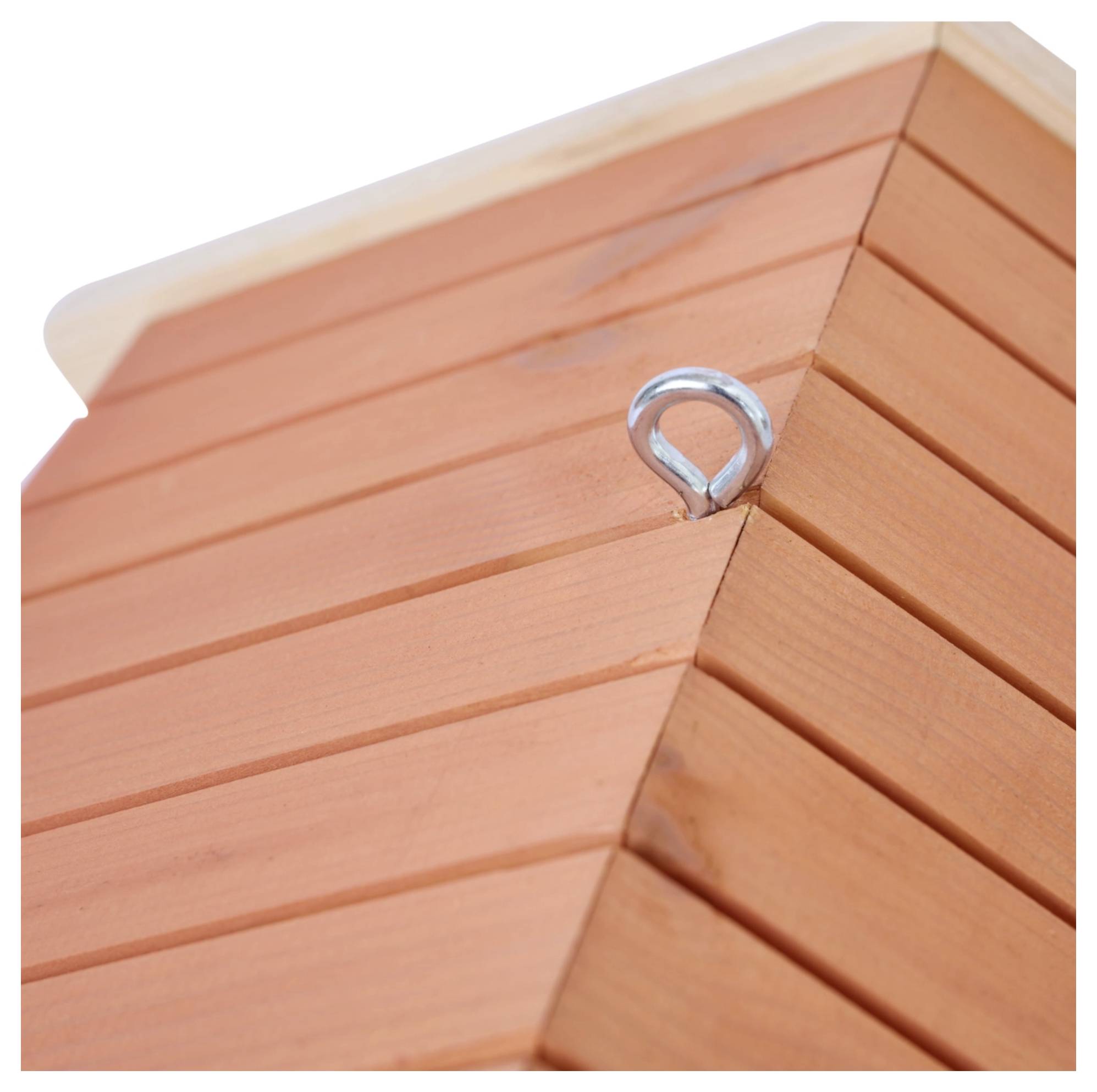 De afbeelding toont een close-up van een houten constructie met een met dakpannen bedekt dak, waarbij een metalen haak is bevestigd nabij de bovenkant.