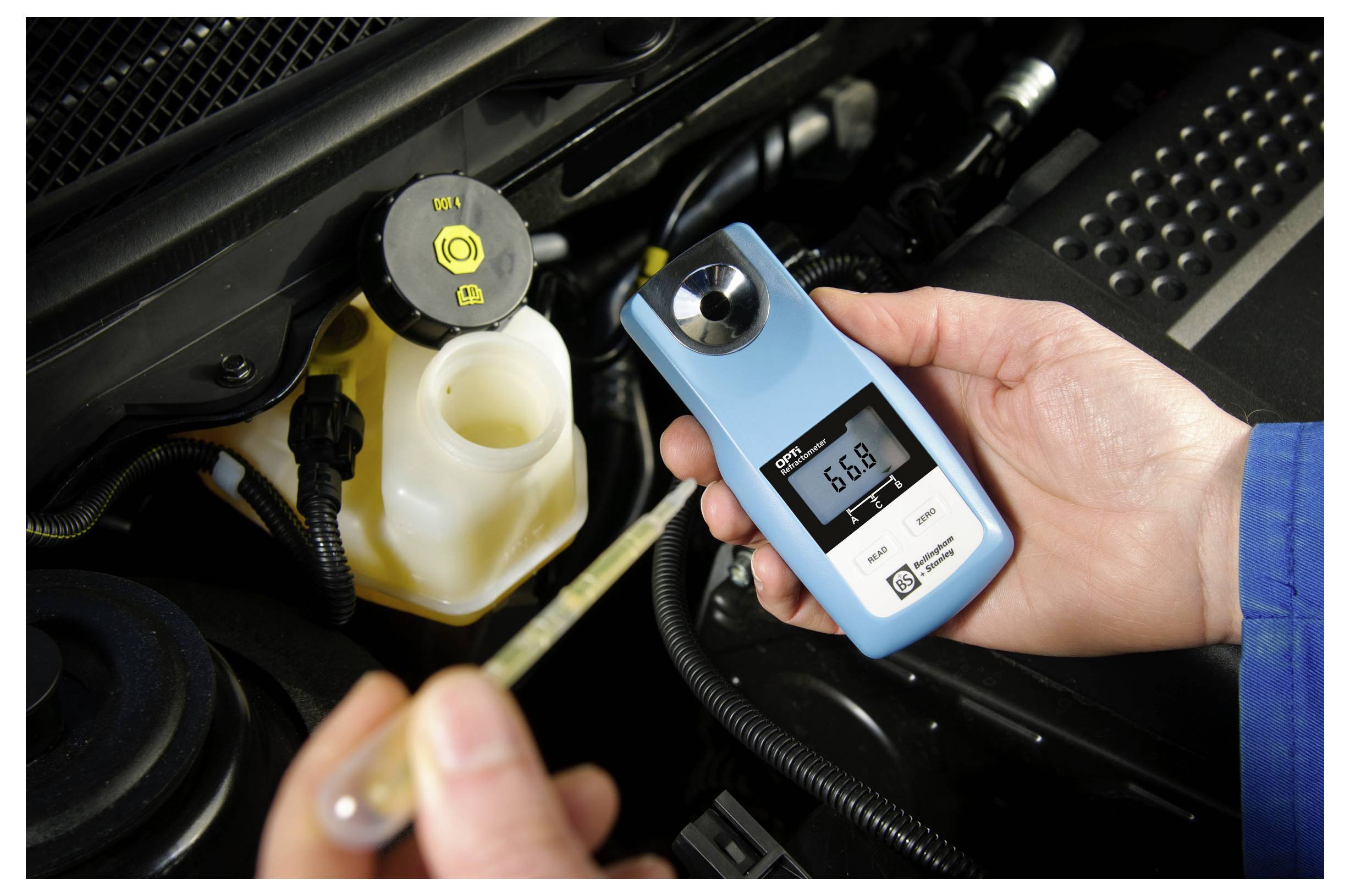 Een persoon die een digitale refractometer vasthoudt met een aflezing van 6,8 naast een open koelvloeistof reservoir in de motorruimte van een auto.