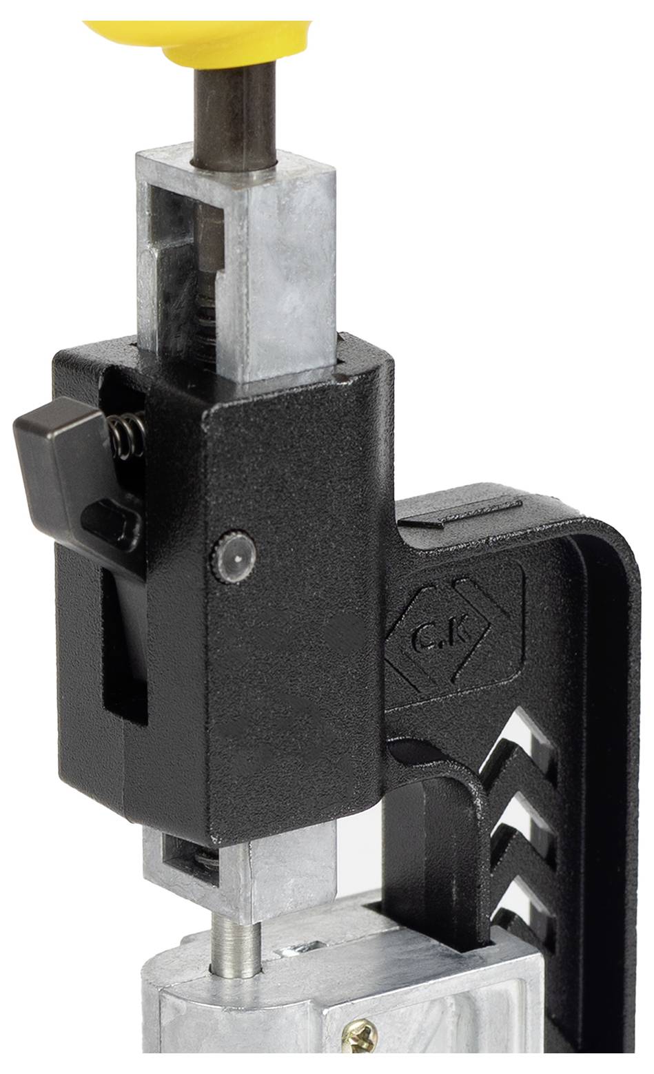 Een close-up van een zwart en zilver vergrendelingsmechanisme met een zeshoekig logo gegraveerd aan de zijkant, bevestigd aan een metalen onderdeel.