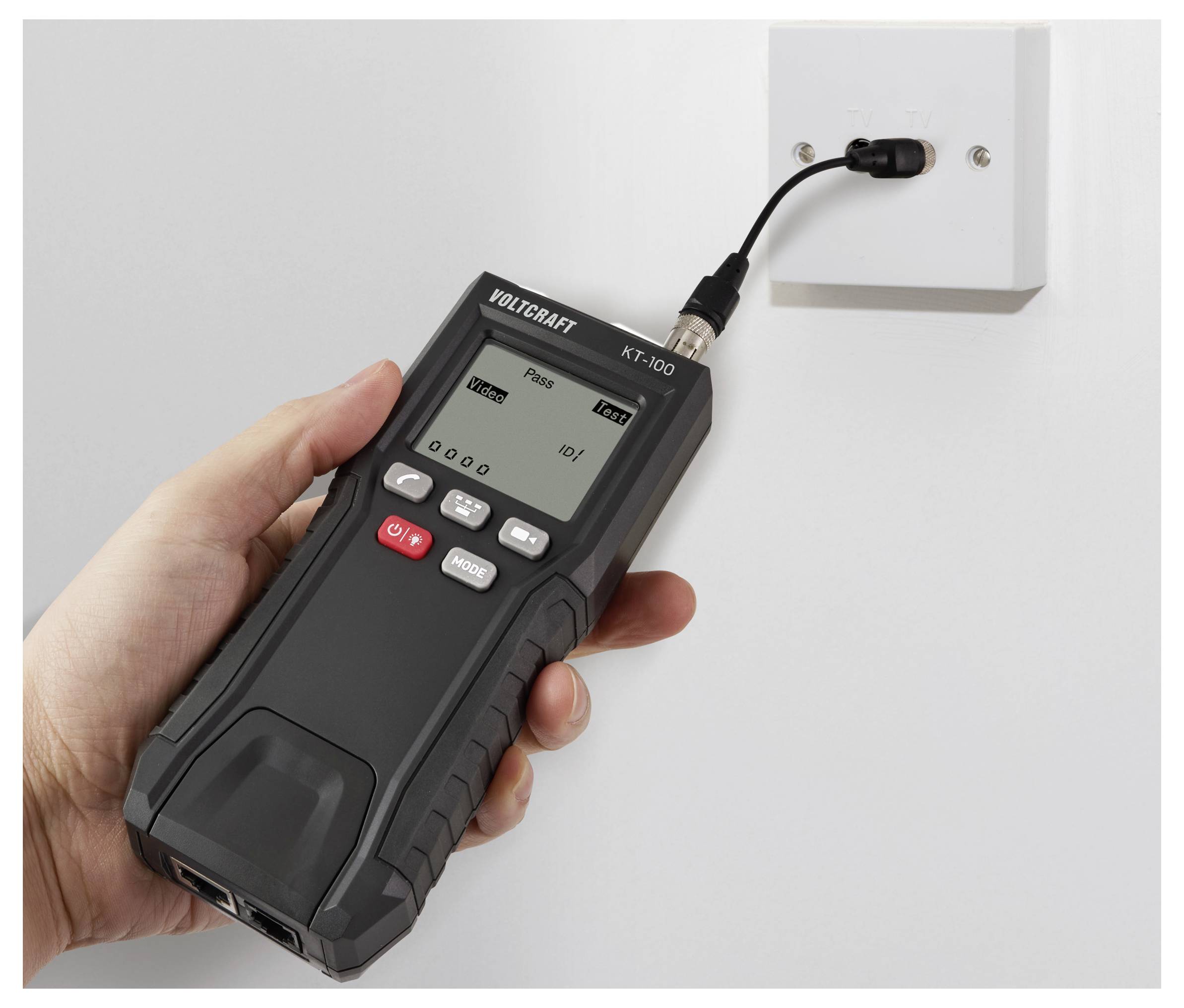 Een persoon houdt een digitaal apparaat vast met 'Pass' op het scherm, aangesloten op een aan de muur gemonteerd stopcontact, terwijl elektrische stroom of spanning wordt getest.